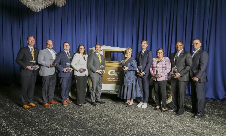 The Academy of Distinguised Engineering Alumni standing in front of the Rambling Wreck