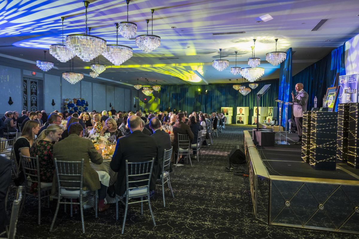 wide shot of the awards event, with people sitting at tables and the stage